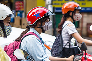 Women driving two-wheelers with masks